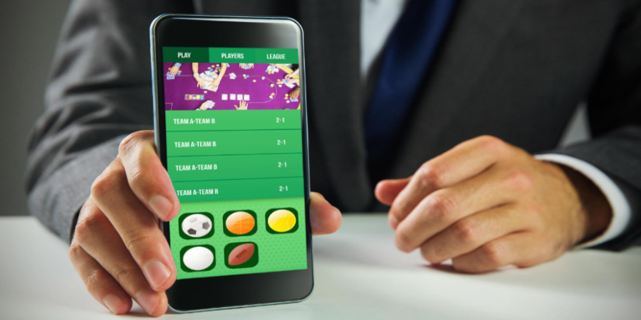Man in suit displaying mobile sports betting application screen